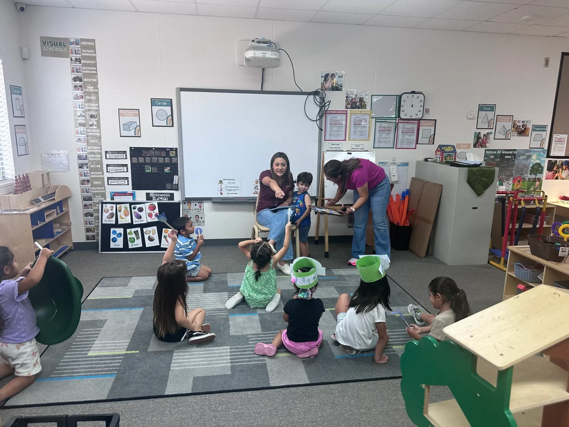 kids are sitting on mat in classroom