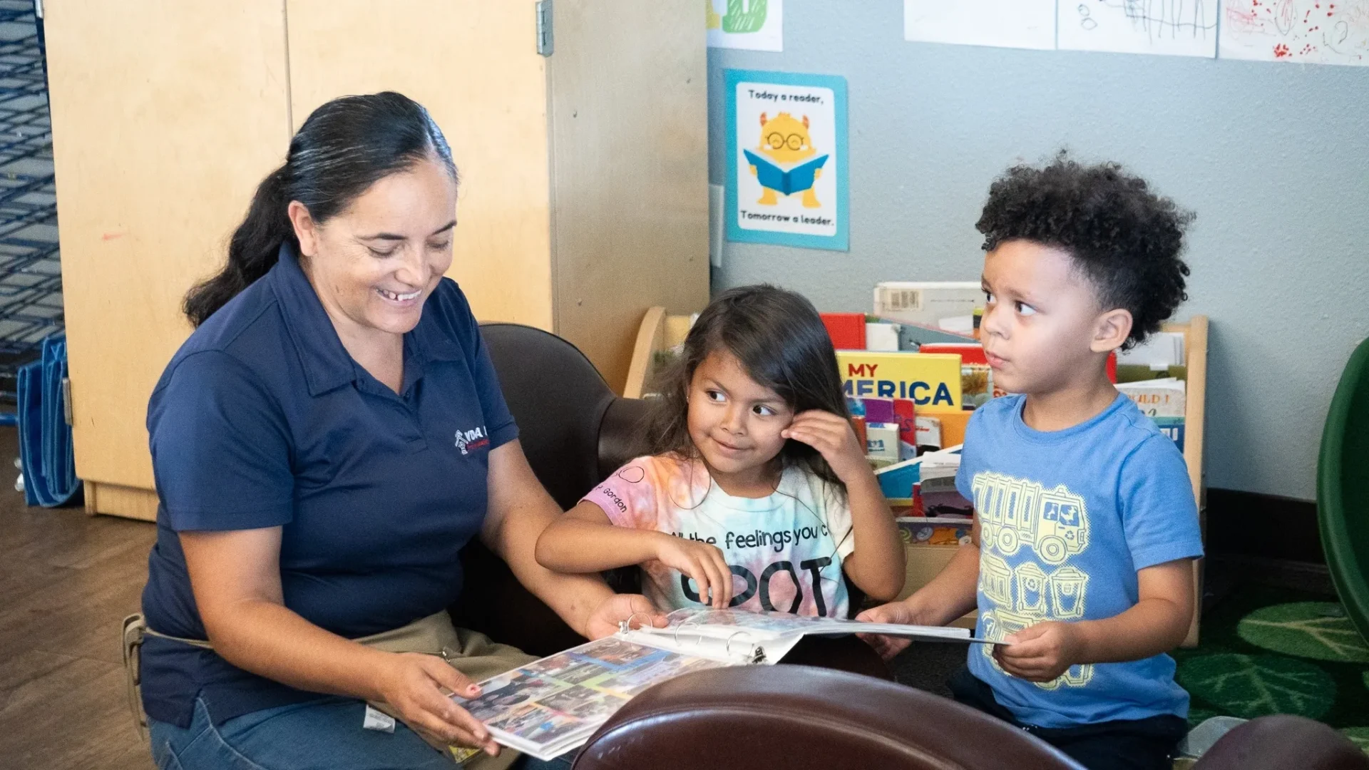 a woman and two kids reading a book