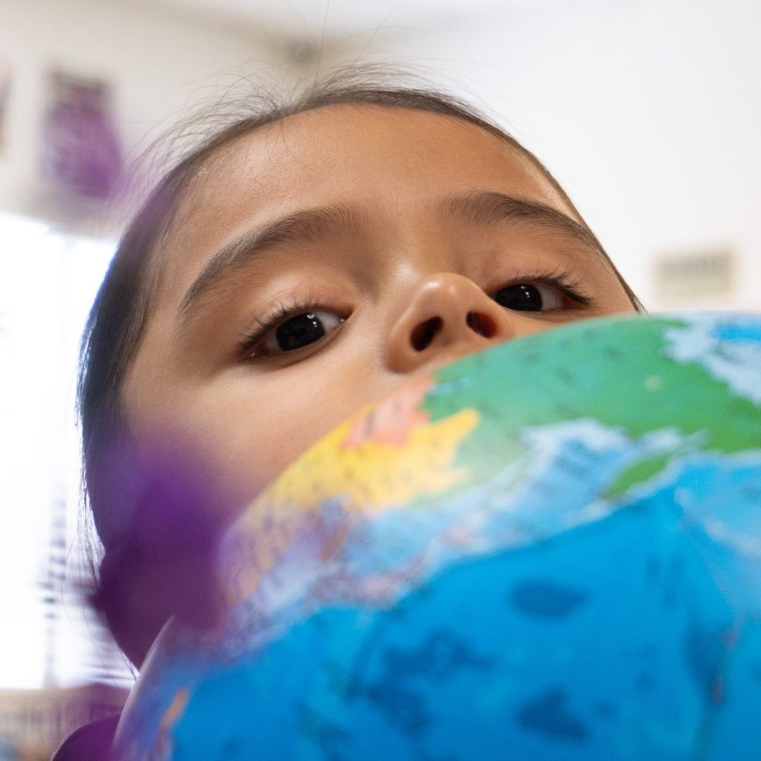 A child looking closely at a globe, exploring geography. A child looking closely at a globe, exploring geography.