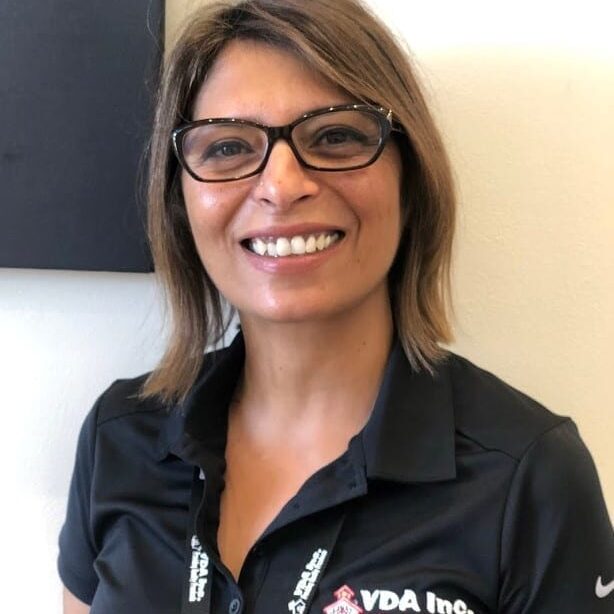 Smiling woman wearing glasses and a black shirt with a name tag. Smiling woman wearing glasses and a black shirt with a name tag.